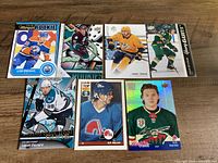 Front view of all seven hockey rookie cards spread on table