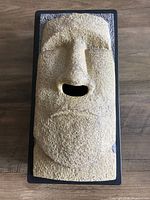 Front view of Moai head tissue box cover showing nose opening and stone texture
