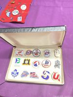 Open case showing all 15 pins arranged on velvet lining