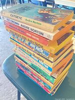 Stack of 15 Andre Norton paperbacks showing spines with several titles visible