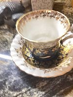 Teacup inside saucer showing gilt pattern