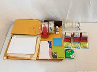 All items grouped showing envelopes, tapes, dispensers, stapler, correction fluid, sticky notes, cards