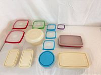Overhead view of all eight containers with their lids arranged by shape and colour