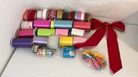 Lot overview of ribbon spools, bow, tape and bagged ribbon pieces