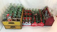 Wooden crates filled with numerous vintage green Coca-Cola bottles and cardboard carriers