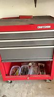 Full view of red Craftsman rolling tool chest with drawers and bins in lower shelf