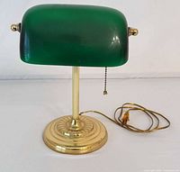 Front view of banker’s lamp showing green shade, brass base and power cord