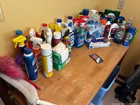 Wide view of table covered with assorted cleaning liquids, wipes, dusters and tools