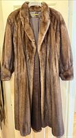Front view of brown mink fur coat on hanger