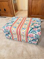 Ottoman angled front view showing upholstery and skirt