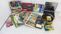 Mixed art supplies including markers, pastels, colored pencils, crayons, chalk, ink pads and paper pads