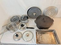 Cookware assortment: stainless saucepans with lids, frying pan, Dutch oven, perforated round pan, baking sheet