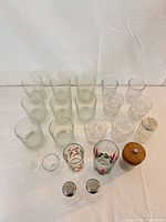 Group of glass tumblers, holiday glasses, shakers and grinder