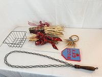 Full lot showing corn bundles, wire basket, fireplace poker, fly swatter, needlepoint cover, wheat ornament