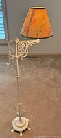 Full view of off-white metal floor lamp with floral shade