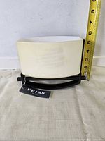 Wall sconce showing glass shade, metal frame, Feiss tag, tape for height