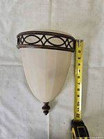 Wall sconce shown with tape; ~12 in height, antique brass frame, white glass shade