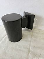 Cylindrical dark bronze wall sconce with mounting plate