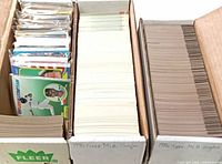 Three cardboard storage boxes filled with sleeved and unsleeved baseball singles