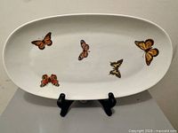 Front view showing butterfly decorations and oval shape