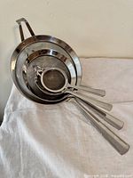 All four nested strainers showing handles and mesh