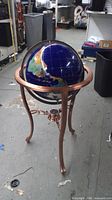 Full view of gemstone globe on copper-tone stand