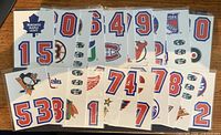 Front view showing multiple sticker sheets with team logos and numbers