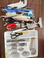 Lot overview showing flatware in tray and pile of assorted utensils