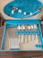 Open box showing knives, forks, spoons in holders