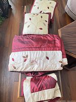 Comforter folded with both shams visible displaying embroidery and colour