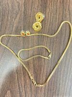 Entire set laid flat showing necklace and both earring pairs