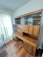 Full front view of wall unit showing shelves, glass doors, lower cabinets