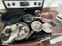 All cookware pieces arranged on stove showing overall lot
