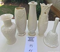 Front view of four vases and bell on table