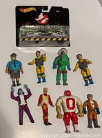 Front view of sealed Hot Wheels pack and eight loose Kenner figures