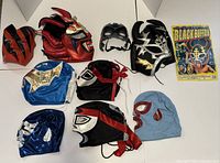 Group shot of nine masks and magazine