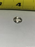 top view of oval faceted lemon yellow topaz next to ruler