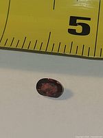 Top view of oval garnet beside ruler showing size