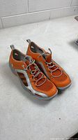 Oblique view showing both sneakers, color, style, overall condition