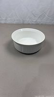 Side view of white round CorningWare dish showing fluted exterior