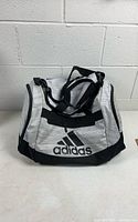 Front view of grey and black Adidas duffel gym bag showing logo and straps