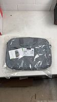 Front view of sealed Lenovo grey laptop bag in packaging