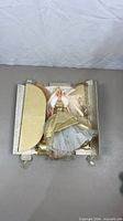 Doll in opened box with detached panels and internal packaging visible