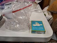 Ziploc bag filled with clear acrylic napkin rings next to boxed set