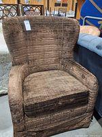 Front view of brown wingback armchair showing seat cushion and upholstery