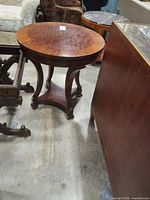 Full view of round veneer side table among other furniture