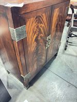 Full view of cabinet showing wood grain, metal corner brackets and latch