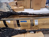 Two broomsticks with orange lights on box labeled grandinroad