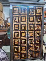 Front view showing geometric patterned doors and tassel pull