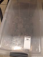 Plastic bin containing multiple clear glass cloches, covered dishes and bowls